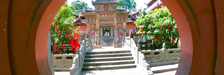 Exploring Huayan Temple. Picture shows a circular entrance with a traditional Chinese-like temple behind and stairs. One of the best things to do in Chongqing