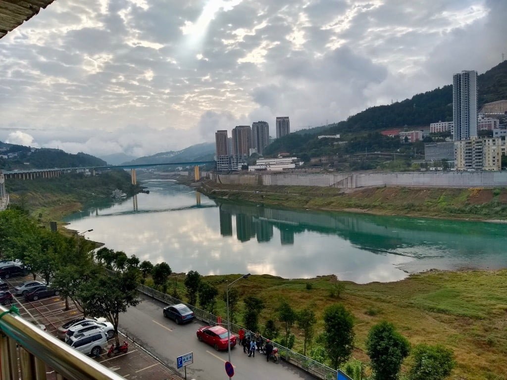 The town of Wulong, with a turquoise river and high-rise apartment buildings