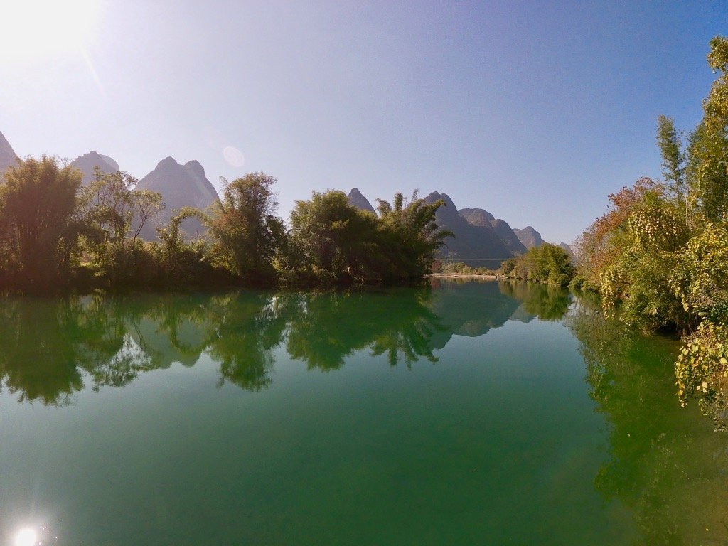 A turquoise river along the Yangshuo cycling path, with karst mountains in the background