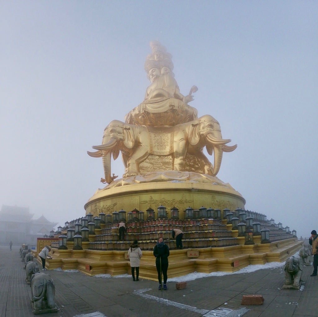 A misty, cloudy statue at the peak of Mount Emei , a trekking option in Sichuan Province, China