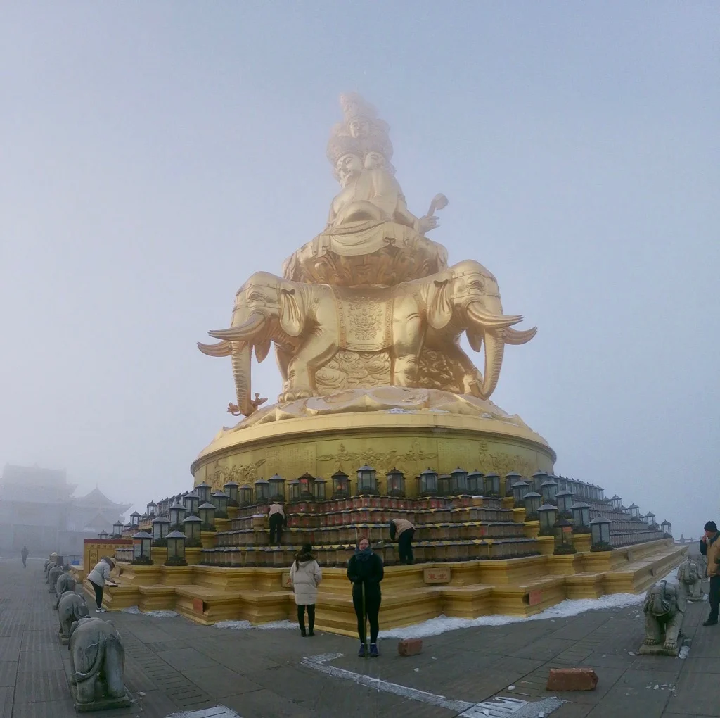 Emeishan A misty, cloudy statue at the peak of Mount Emei , a trekking option in Sichuan Province, China