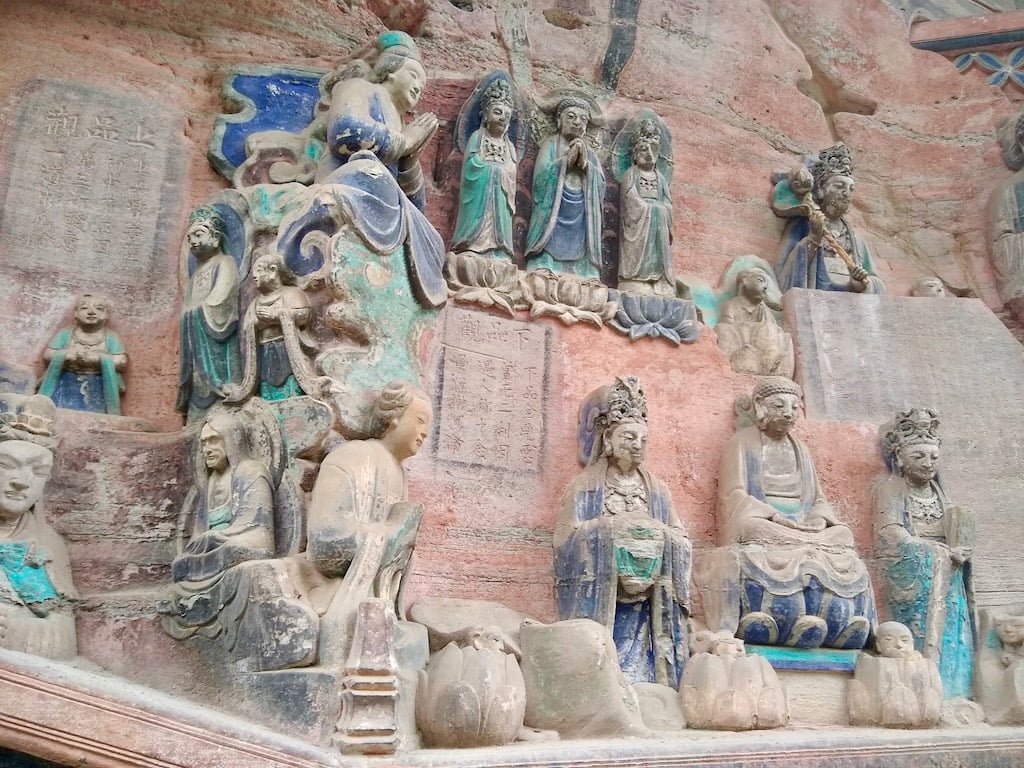 Multiple different carved statues, and painted, at Dazu Rock Carvings at Baodingshan site, Chongqing, China