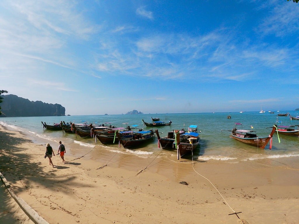 A picture of a beach with long tail boats in Krabi, Thailand; traveling during covid-19