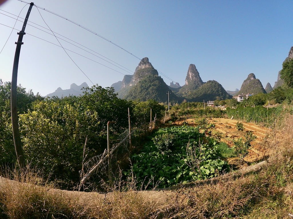 A farm and lots of karst hills in the background, located in Xingping near Guilin, China