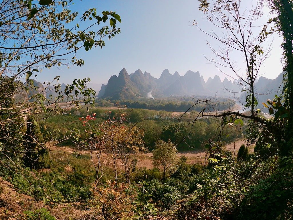A river, partially dried up, and karst hills in the background, located on the way to Shawan from Xingping, China, part of the unknown Guilin attractions