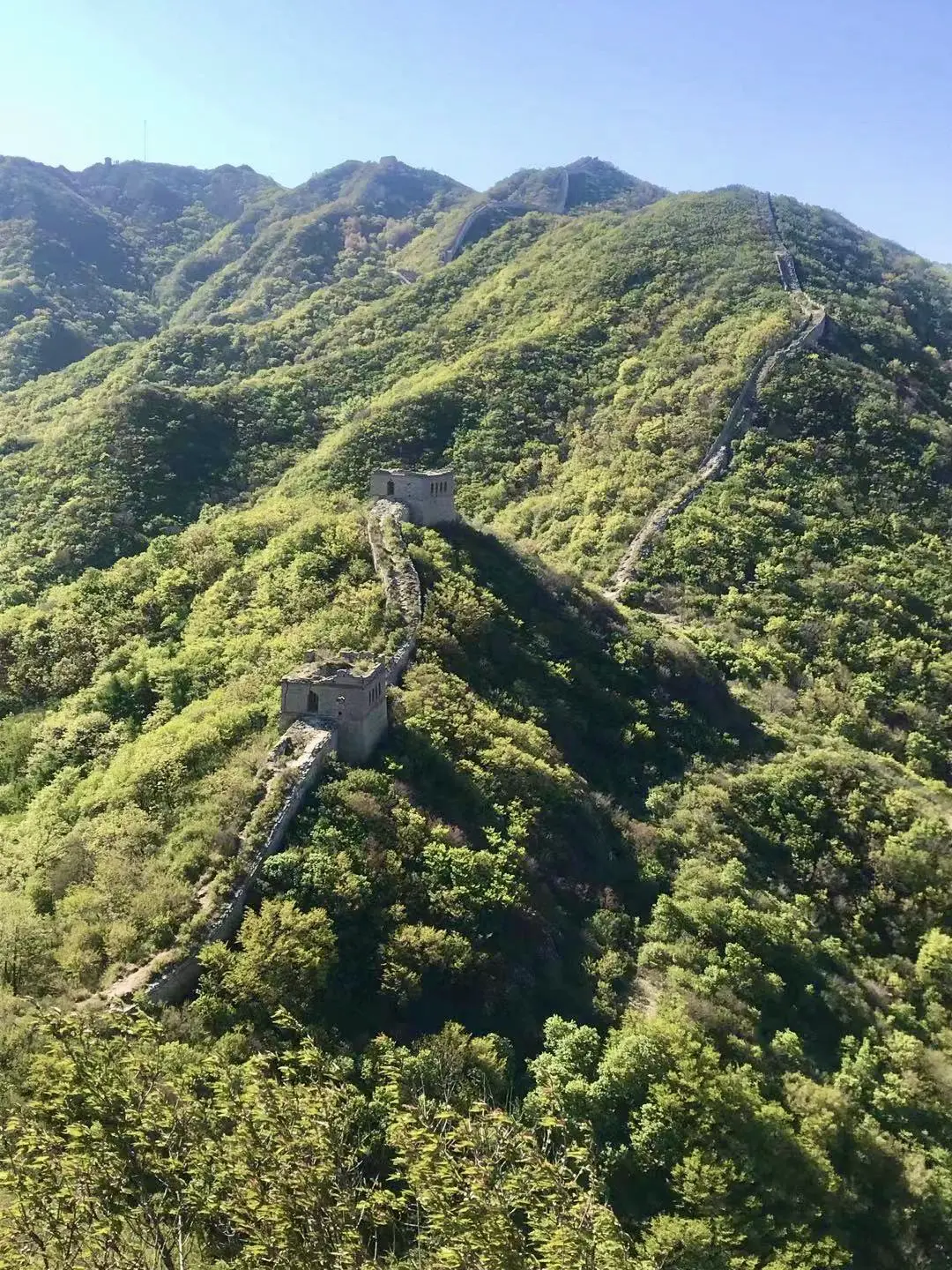 The Great Wall of China, outside Beijing, China Rolling green mountains with a wall of bricks and a watchtower, part of the Great Wall of China.